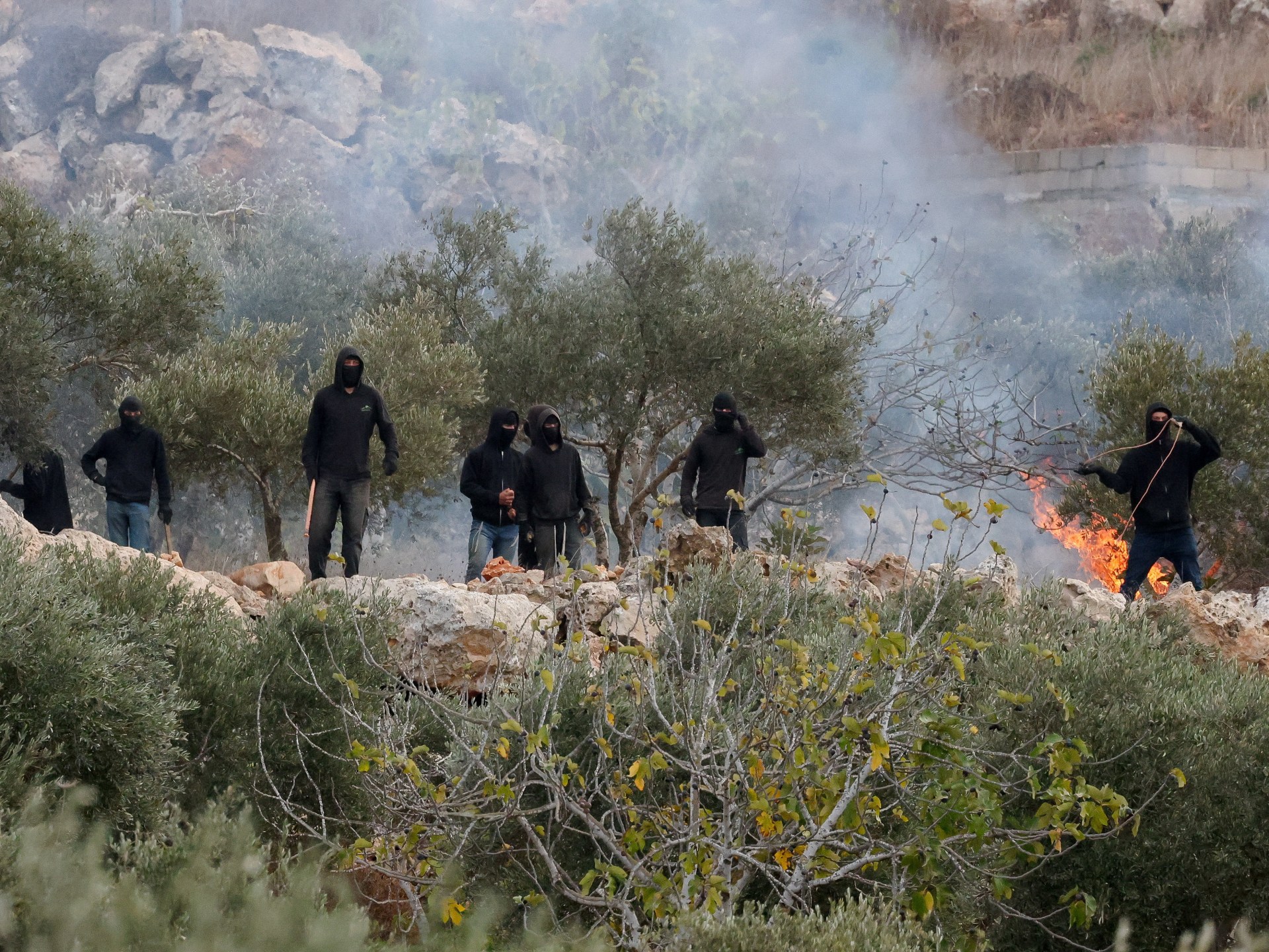 Video shows armed settlers attacking journalist, activist in West Bank