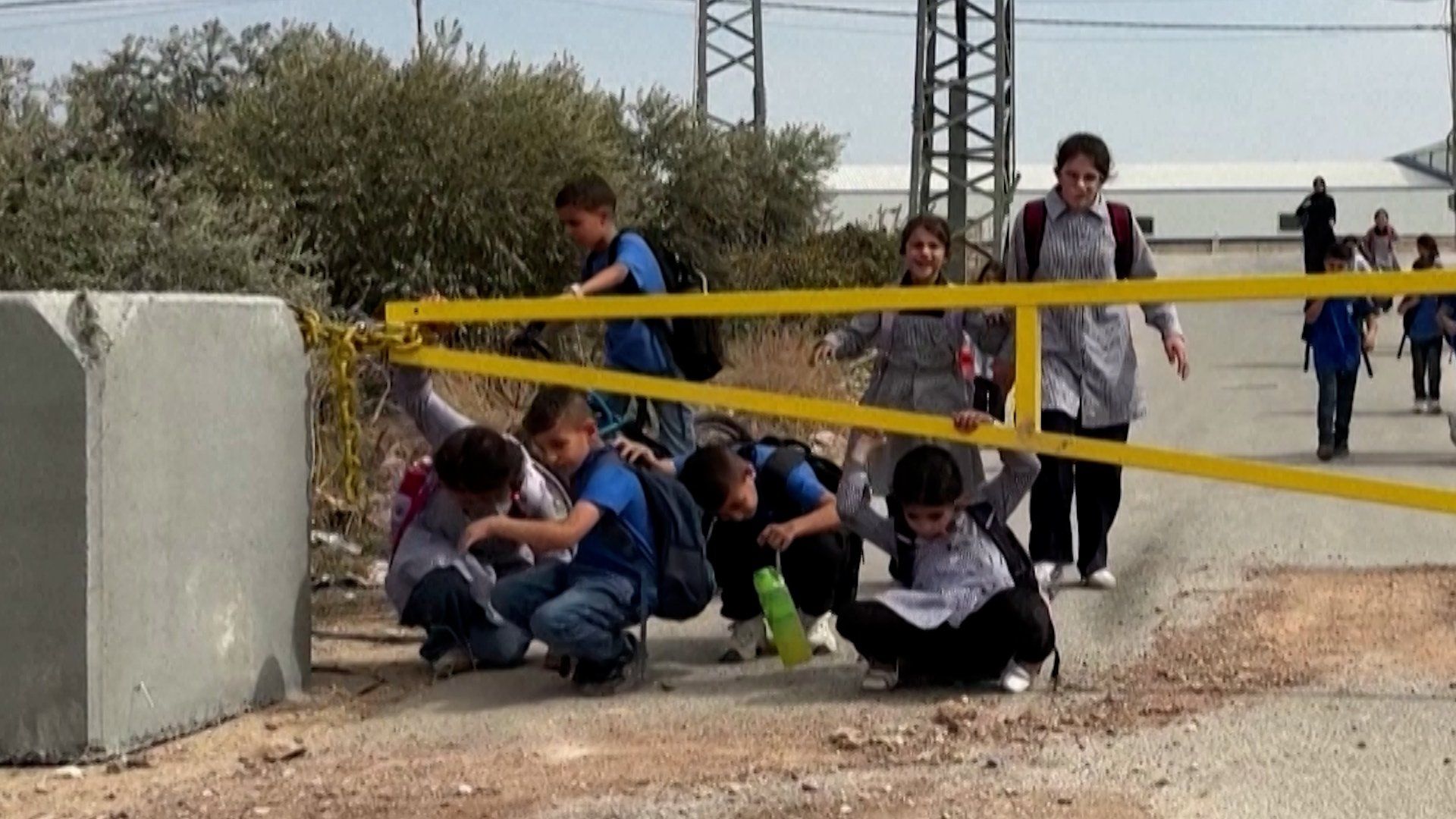 Palestinian schoolchildren forced to crawl under military barriers in Jenin